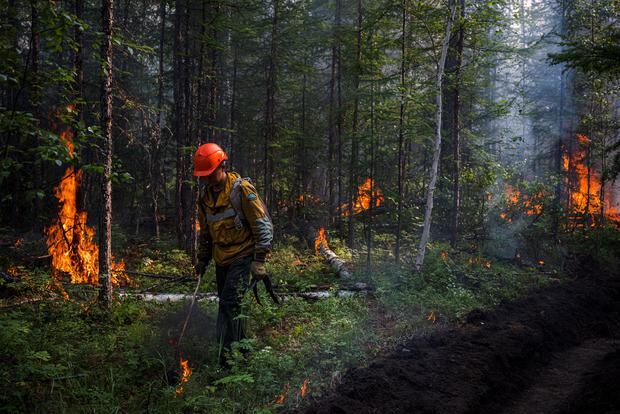 A firefighter fights the flames of a forest fire in Russia, on July 26, 2021. (Photo: Dimitar DILKOFF / AFP)