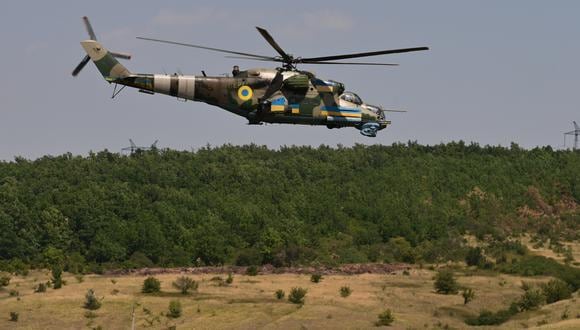 Una fotografía tomada el 9 de julio de 2022 en el este de Ucrania muestra un helicóptero de ataque Mi-24 sobrevolando un campo. (Foto: MIGUEL MEDINA / AFP)