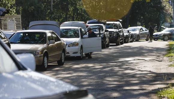 Los automovilistas esperan en fila durante la distribución de sacos de arena, antes del huracán Idalia, en el Parque MacFarlane en Tampa, Florida, el lunes 28 de agosto de 2023. (Ivy Ceballo/Tampa Bay Times vía AP).