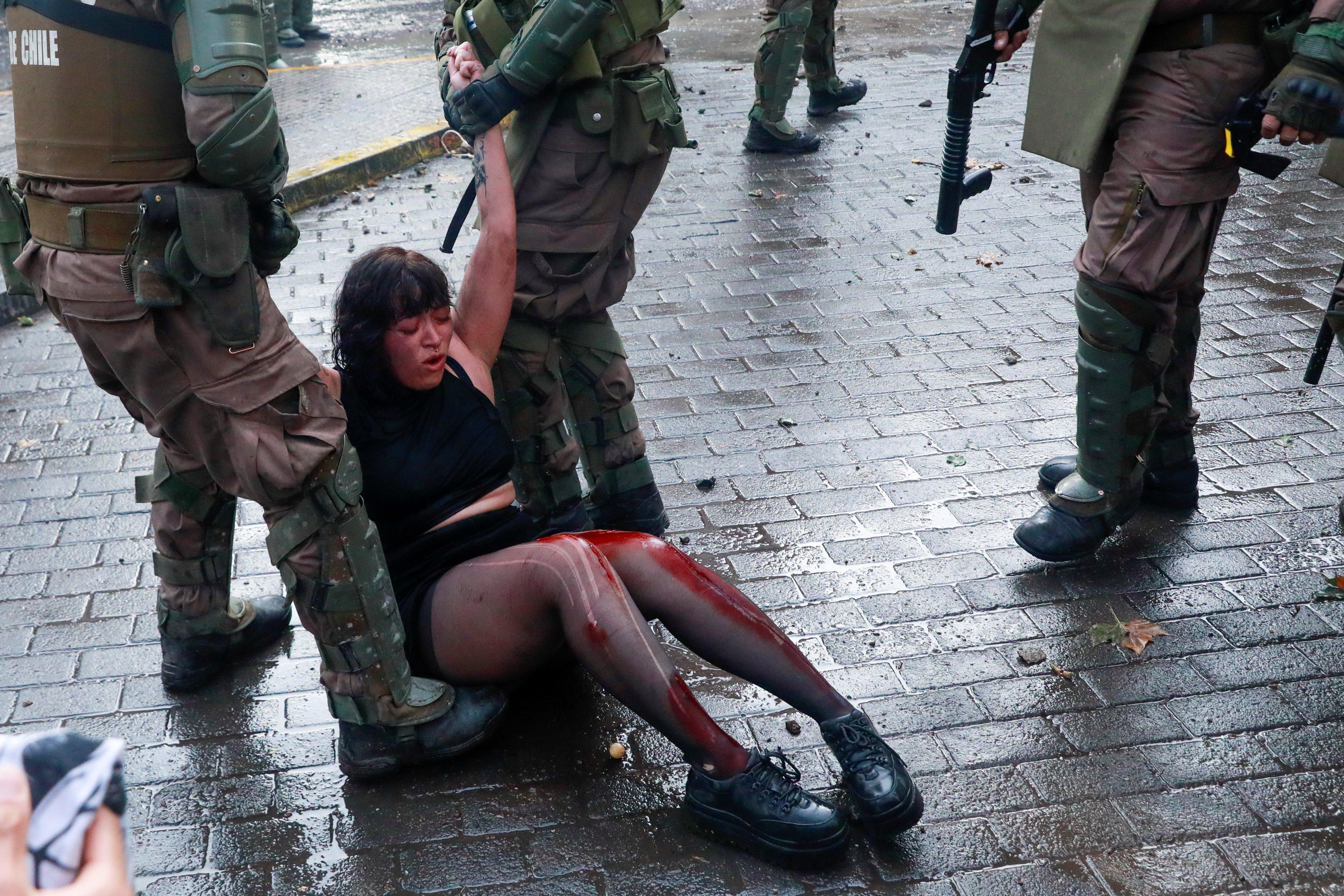 Una manifestante herida es detenida por Carabineros durante el "super lunes" de protestas convocadas en contra del gobierno de Sebastián Piñera, en Santiago de Chile. (Reuters)