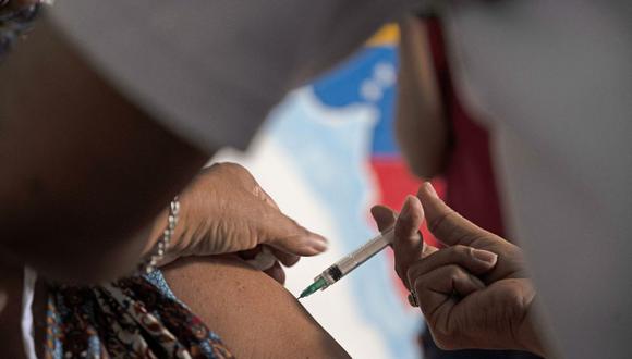 Un docente recibe una dosis de la vacuna COVID-19 desarrollada por Sinopharm de China en un centro de vacunación en la escuela secundaria Miguel Antonio Caro en Catia, Venezuela, el 8 de marzo de 2021. (Yuri CORTEZ / AFP).