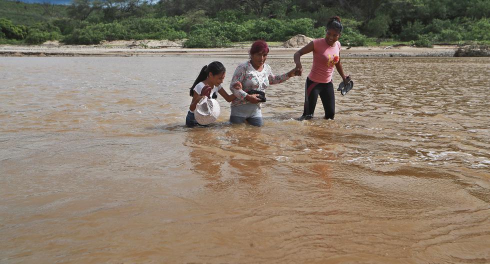 En el distrito de Casitas, Tumbes, personas cruzan las quebradas llenas de agua.