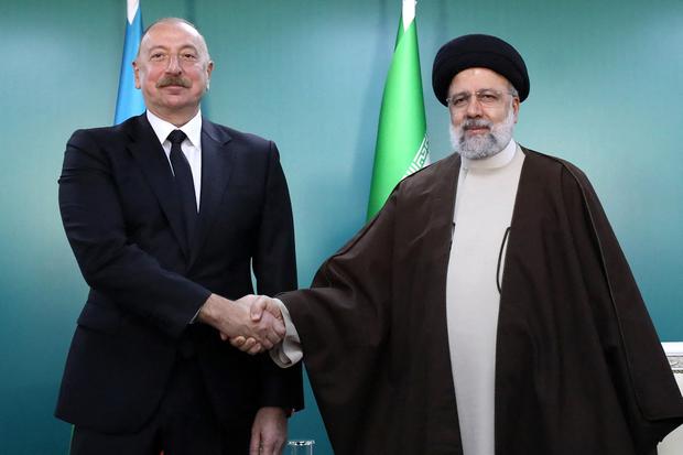 Iranian President Ebrahim Raisi (left) and his Azerbaijani counterpart Ilham Aliyev meet before the opening ceremony of Qiz Qalasi, the third jointly built dam.  (Photo by Iranian Presidency / AFP).