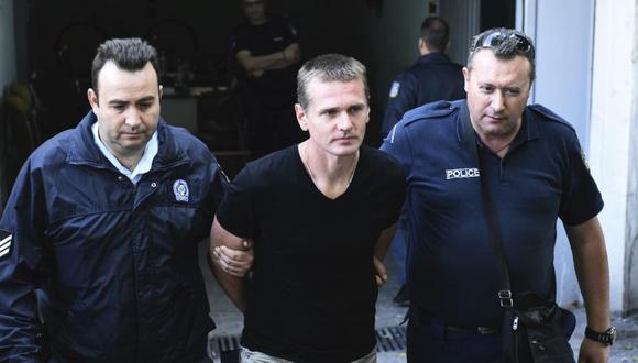 Agentes de policía escoltan a Alexander Vinnik, en el centro, cuando salen de un juzgado en la ciudad de Tesalónica, en el norte de Grecia.