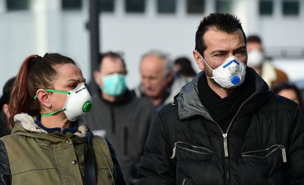 Un grupo de personas usa mascarillas cerca de un supermercado en la ciudad de Casalpusterlengo, en Italia, país donde se han registrado más de 100 contagios por coronavirus. (AFP / Miguel MEDINA).