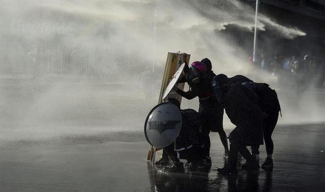 Manifestantes y Carabineros chocan hoy durante una protesta cerca al Palacio de La Moneda, en Santiago de Chile. (EFE/Alberto Valdés).