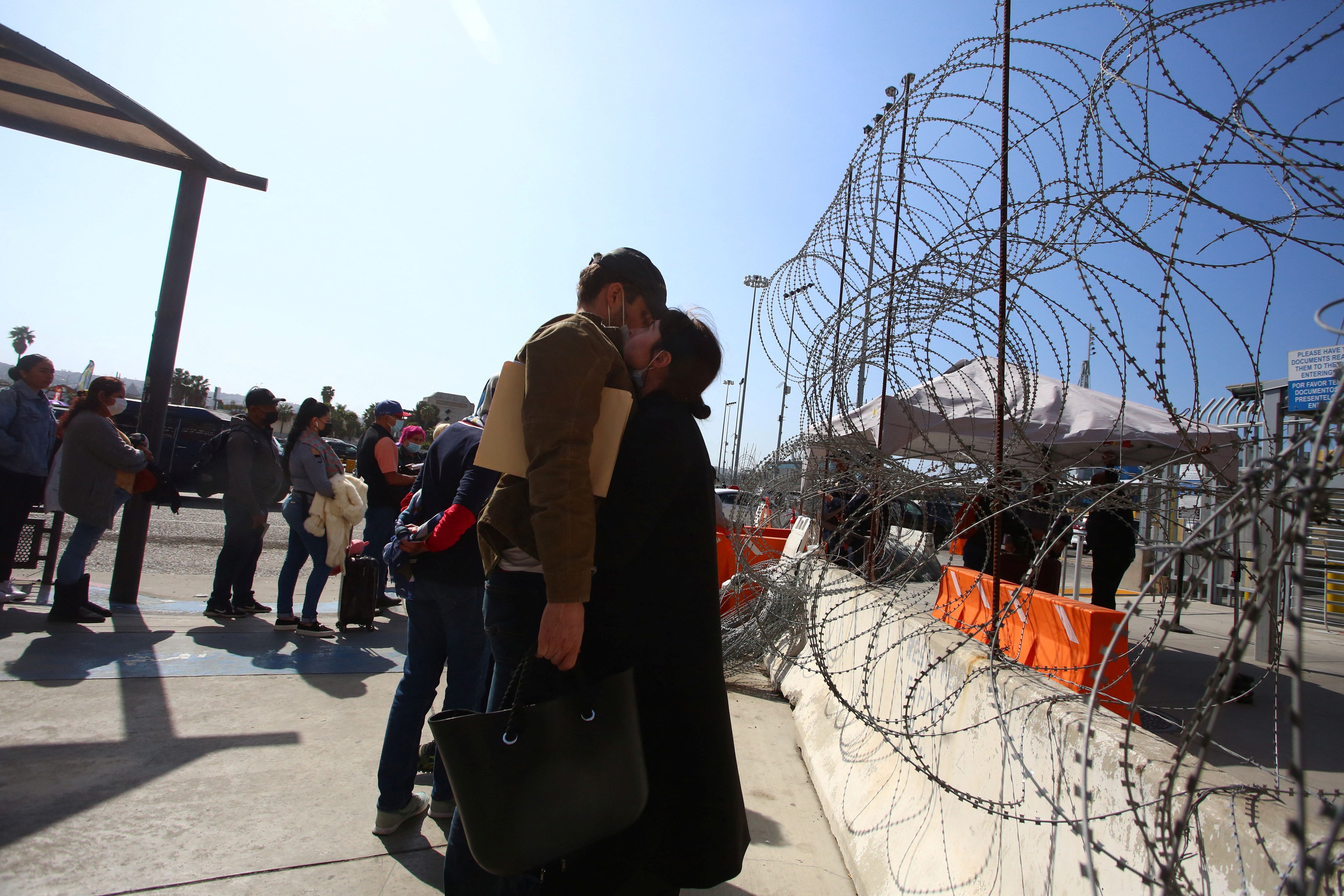 A Ukrainian woman hugs her boyfriend as he waits for a humanitarian visa outside the San Ysidro port of entry on the US-Mexico border in Tijuana, Mexico.  (REUTERS/Jorge Duenes).