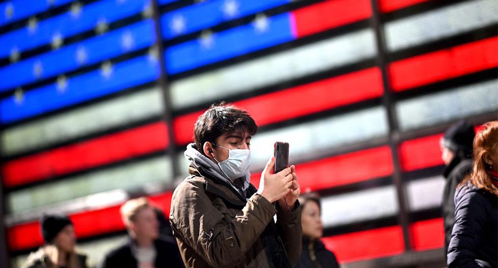 Un hombre usa mascarilla mientras mientras revisa su celular en Times Square, Nueva York, Estados Unidos, en plena pandemia de coronavirus. (Johannes EISELE / AFP).