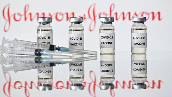 Una imagen ilustrativa muestra viales con adhesivos de vacuna Covid-19 adheridos y jeringas con el logotipo de la compañía farmacéutica estadounidense Johnson & Johnson. (Foto: AFP / JUSTIN TALLIS).