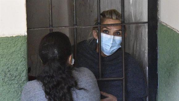 La expresidenta interina de Bolivia Jeanine Áñez se asoma desde una celda de las Fuerza Especial de Lucha Contra el Crimen (FELCC) en La Paz. (Foto: EFE).