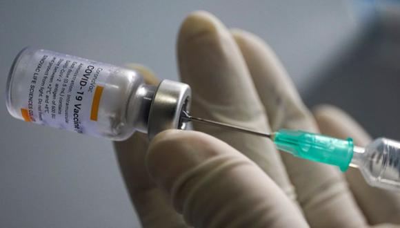 FILE PHOTO: A health worker holds a syringe and a vial of the Sinovac coronavirus disease (COVID-19) vaccine at a market after hundreds of local residents in the district tested positive for COVID-19 in Bangkok, Thailand, March 17, 2021. REUTERS/Athit Perawongmetha/File Photo