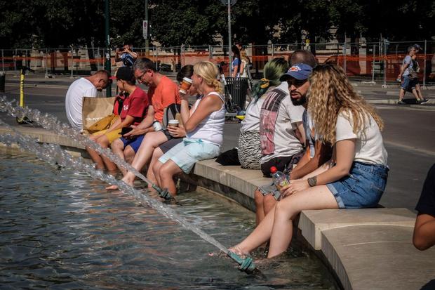 People look for a soda at the fountain in Piazza Castello on a very hot day, Milan, Italy, August 9, 2021.