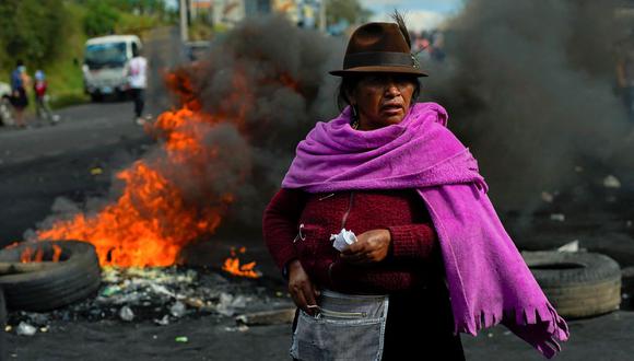 Una mujer indígena que llegó en caravana para sumarse a una movilización nacional contra el gobierno de Ecuador bloquea una vía y monta barricadas en el sur de Quito, el 15 de junio de 2022. (VERONICA LOMBEIDA / AFP).