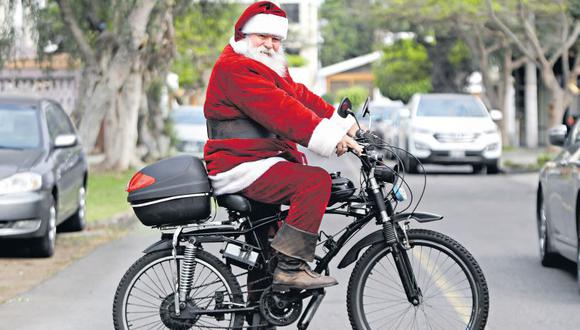 Don Sergio, o simplemente, Papa Noel, lleva 27 años trabajando como este personaje navideño. A falta de un trineo y renos para sobrellevar el tráfico limeño, él utiliza una bicimoto. (Foto: Víctor Gonzales / El Comercio)
