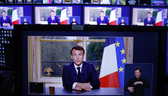 Una foto de monitores en una sala de control de medios muestra al presidente francés Emmanuel Macron durante un discurso televisado a la nación, realizado desde el Palacio del Elíseo, después de promulgar una ley de reforma de las pensiones, en París, el 17 de abril de 2023. (Foto de Ludovic MARIN / AFP)