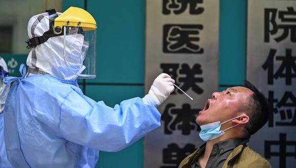 Un trabajador médico toma una muestra de un hisopo de un hombre que está siendo analizado por el nuevo coronavirus COVID-19 en Wuhan, en la provincia central china de Hubei. (Foto: AFP / Hector RETAMAL).