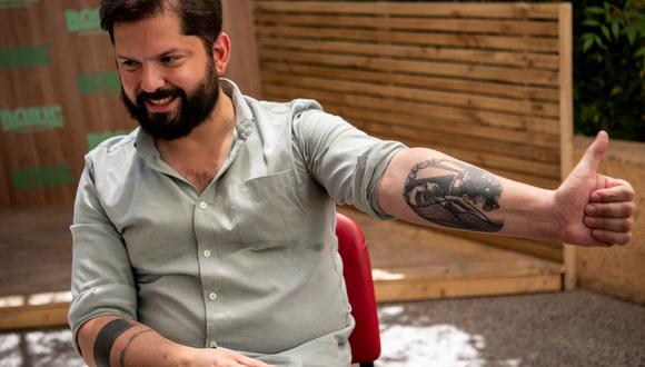 Gabriel Boric muestra uno de sus tatuajes durante una entrevista con AFP en Santiago, el 28 de octubre de 2021. (MARTIN BERNETTI / AFP).