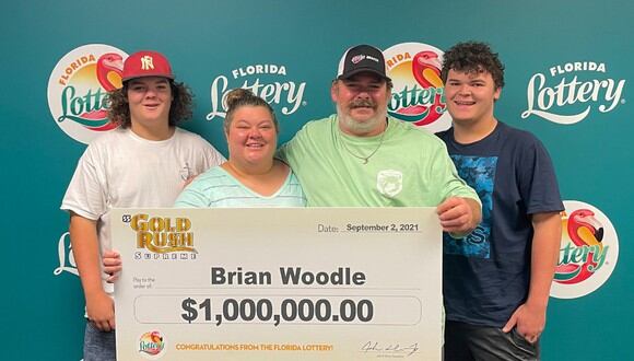 Brian Woodle posa con un cheque después de ganar un millón de dólares en la lotería. (Foto: Florida Lottery)
