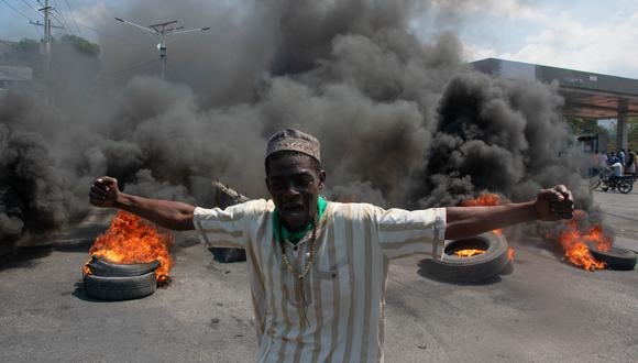 Un manifestante reacciona mientras se queman neumáticos en la calle durante una manifestación tras la dimisión del Primer Ministro de Haití Ariel Henry, el 12 de marzo de 2024. (Foto de Clarens SIFFROY / AFP).