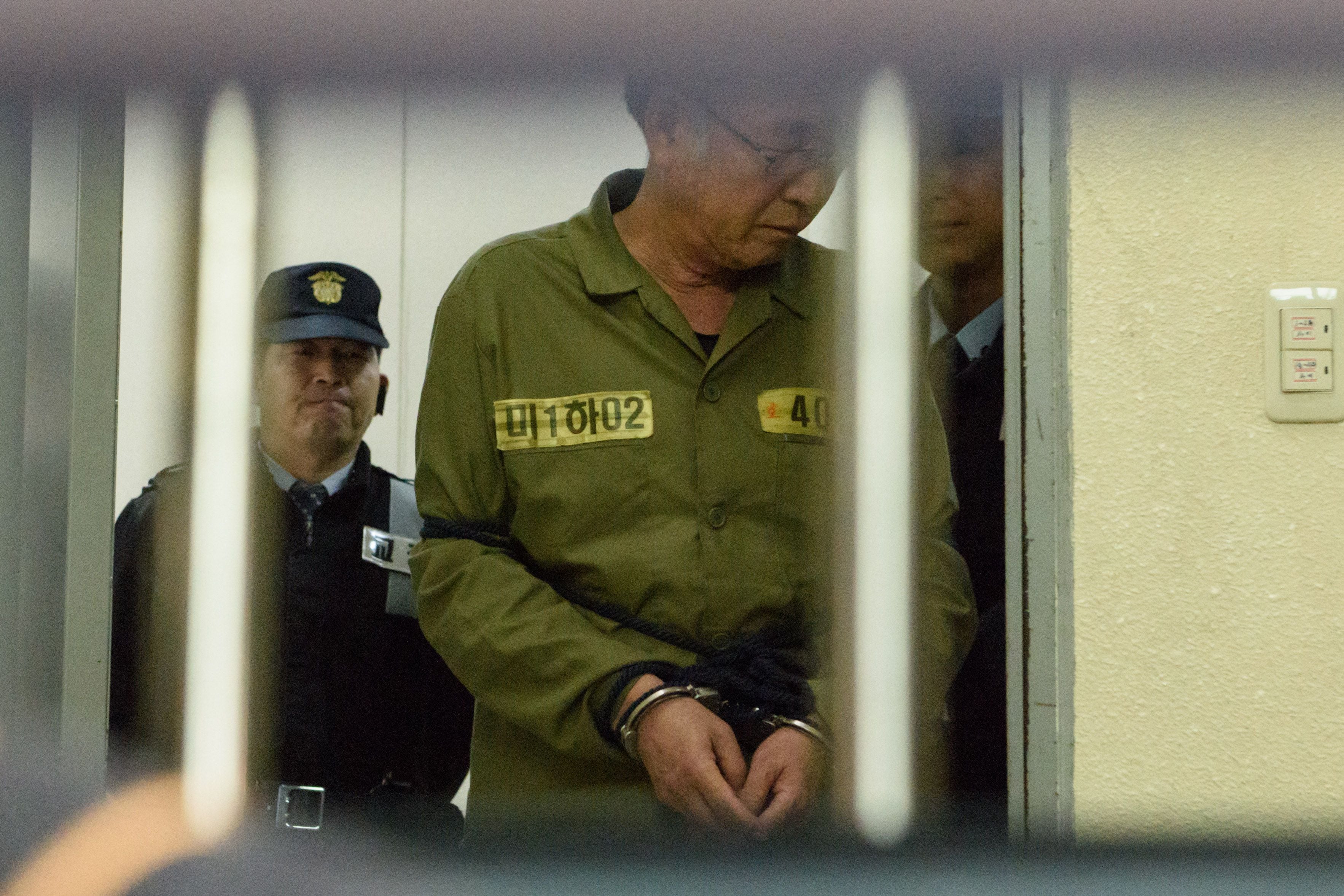 Sewol ferry captain Lee Jun-Seok is escorted after arriving at a court in Gwangju on November 11, 2014. (Photo by ED JONES/AFP).