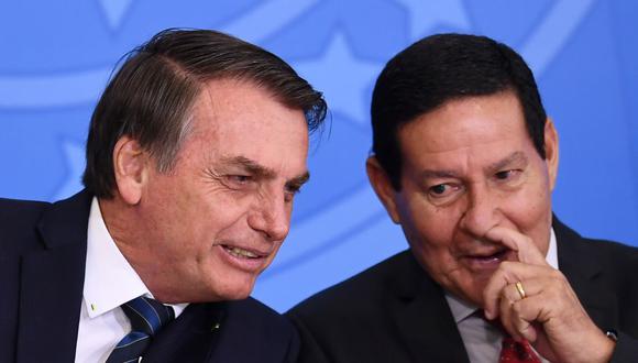 El presidente de Brasil, Jair Bolsonaro (izq.) y su vicepresidente Hamilton Mourao en una imagen del 4 de julio de 2019. Ambos se han contagiado de coronavirus. (Foto de EVARISTO SA / AFP).
