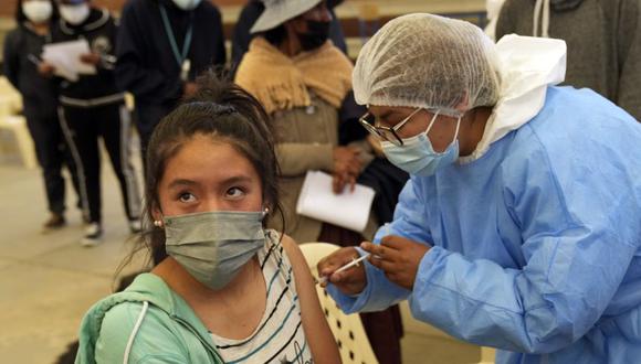 Un trabajador de la salud le da a un estudiante una dosis de la vacuna Pfizer COVID-19 durante una campaña de vacunación para jóvenes de 16 y 17 años en la Escuela Primero de Mayo en La Paz, Bolivia. (Foto AP / Juan Karita)