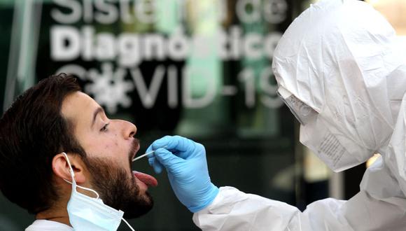Un trabajador de la salud obtiene una muestra de hisopo de un hombre para una prueba de PCR de coronavirus en Guadalajara, estado de Jalisco, México, el 14 de abril de 2021. (ULISES RUIZ / AFP).