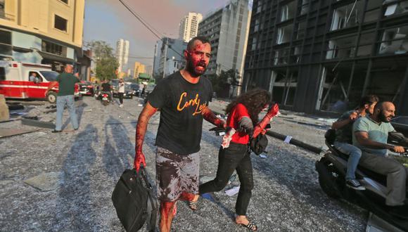 Personas heridas caminan cerca del sitio de la explosión. (Foto por STR / AFP).