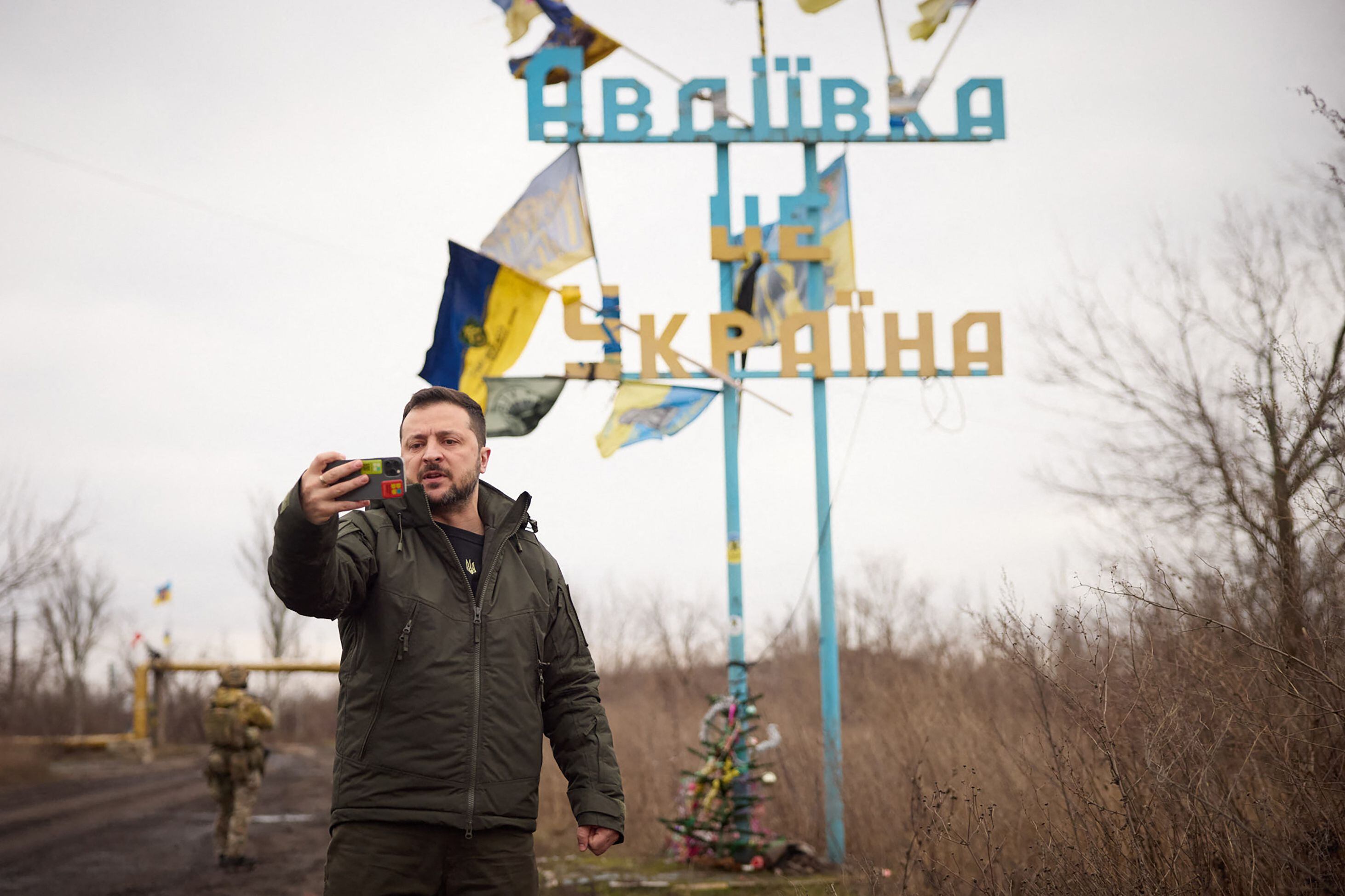 This December 29, 2023 photo shows President Volodymyr Zelensky recording a speech in front of a sign that says 