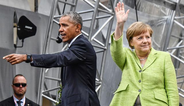 Former US president Barack Obama and German Chancellor Angela Merkel leave the stage after their panel discussion during the Protestant church day (Kirchentag) event at the Brandenburg Gate (Brandenburger Tor) in Berlin on May 25, 2017. ?Barack Obama attends a panel dicussion with Angela Merkel in Berlin before heading to Baden-Baden to receive a German media prize. / AFP / John MACDOUGALL