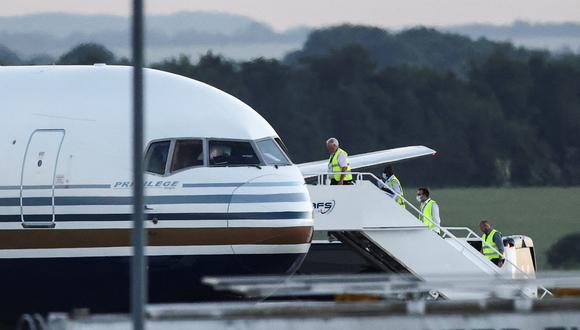 Miembros del staff entran al avión que debió transportar, desde Gran Bretaña, migrantes de Ruanda hacia su país de origen. REUTERS