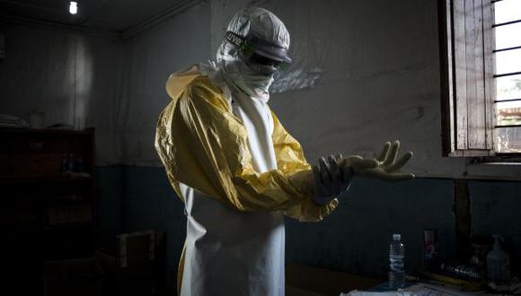 Un trabajador de salud se pone su equipo de protección personal antes de ingresar a la zona roja de un Centro de Tratamiento del Ébola. (Foto: AFP)