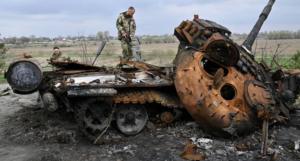 Los militares de Ucrania miran un tanque ruso destruido en una carretera en la aldea de Rusaniv, en la región de Kiev, el 16 de abril de 2022. (Genya SAVILOV / AFP).