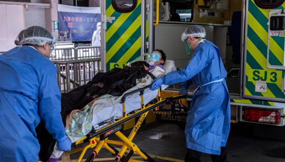 Una persona es trasladada a una ambulancia fuera del Hospital Queen Elizabeth en Hong Kong, ya que el gobierno anunció que el hospital se utilizará solo para pacientes con Covid-19. (Foto: ISAAC LAWRENCE / AFP)