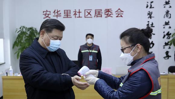 El presidente de China, Xi Jinping, se toma la temperatura durante su visita a un barrio de Beijing, como parte de las medidas para prevenir el contagio del coronavirus de Wuhan. (AP).