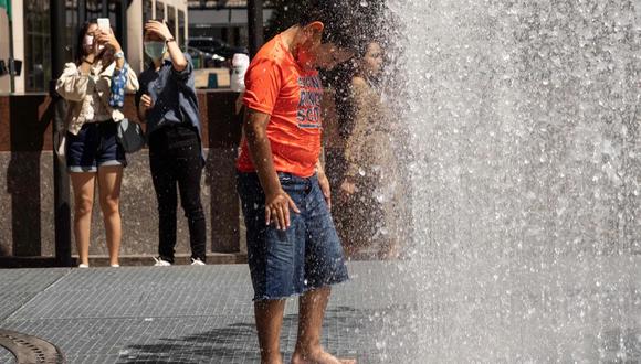 La gente juega en la escultura a base de agua del artista Jeppe Hein titulada "Changing Spaces" en el Rockefeller Center Plaza, en la ciudad de Nueva York.
(YUKI IWAMURA - AFP).