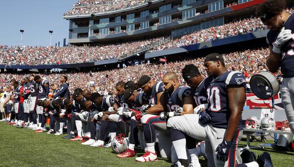 Jugadores de los Patriots de Nueva Inglaterra hincan la rodilla en el suelo durante el himno a modo de protesta por la brutalidad policial. (AP)