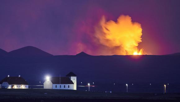 Esta foto tomada el 5 de mayo de 2021 muestra Bessastadir, la residencia oficial del presidente de Islandia, con el resplandor de la lava que sale de una fisura cerca de Fagradalsfjall. (Foto de Halldor KOLBEINS / AFP).
