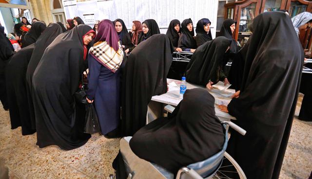Iranian women cast their ballots for the presidential elections at a polling station at the Lorzadeh mosque in southern Tehran on May 19, 2017.  / AFP / ATTA KENARE