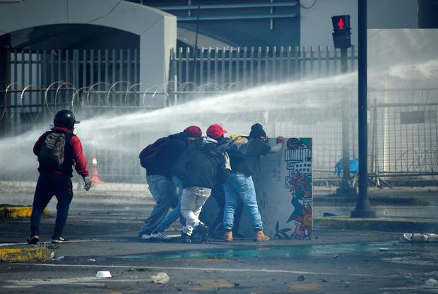 Manifestantes chocan con la policía en los alrededores de la sede de la Contraloría General de la República, en el Parque Arbolito de Quito el 23 de junio de 2022. (RODRIGO BUENDIA / AFP).