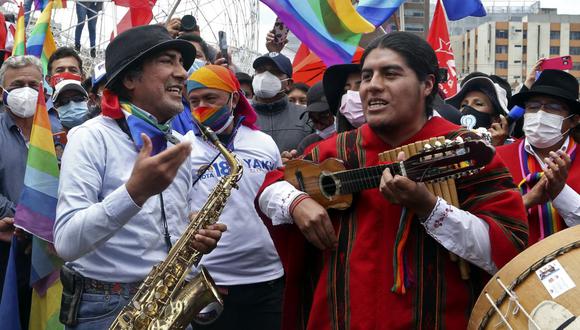 El ex candidato presidencial ecuatoriano Yaku Pérez (izq.) toca el saxofón mientras celebra su cumpleaños con simpatizantes, antes de una marcha hacia el Consejo Nacional Electoral (CNE), en Quito, el 26 de febrero de 2021. (Foto de Cristina Vega RHOR / AFP).