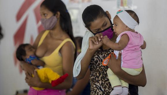 Mujeres cargan a sus bebés mientras esperan ver a un médico en una clínica de la organización Médicos Sin Fronteras (MSF) instalada en Barcelona, ​​Estado Anzoátegui, Venezuela. (Foto de Pedro Rances Mattey / AFP).