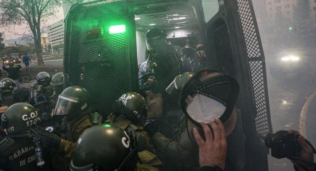 Agentes de la policía antidisturbios chilenos arrestan a un manifestante durante una protesta contra la policía en reacción a un video que parece mostrar a un oficial empujando a un joven desde un puente el día anterior en una protesta, en Santiago. (Foto: AP / Esteban Felix)