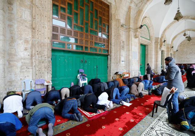 Los musulmanes palestinos se reúnen para realizar sus oraciones del viernes frente a las puertas cerradas de la mezquita Al-Aqsa en la Ciudad Vieja de Jerusalén. (Foto: AFP)