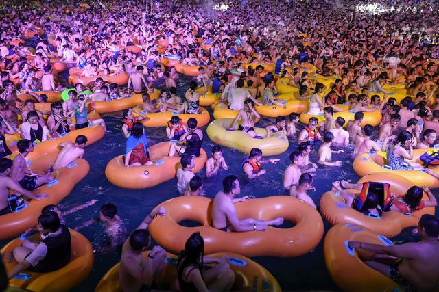 Esta foto tomada el 15 de agosto muestra a asistentes a un concierto electrónico mientras se refrescan en una piscina en Wuhan, en la provincia central china de Hubei. (Foto: AFP)