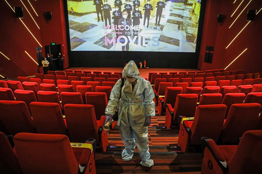 Un trabajador indio desinfecta asientos en la sala de cine INOX durante los preparativos para la reapertura de salas de cine en Bombay, India, 13 de octubre de 2020. (EFE / EPA / DIVYAKANT SOLANKI).