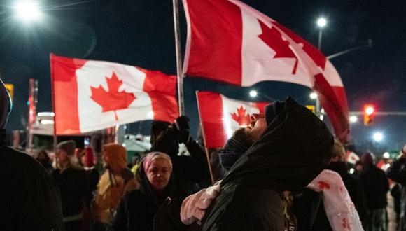 Los manifestantes ondean banderas canadienses mientras bloquean el acceso al puente Ambassador durante una manifestación en Windsor, Ontario, Canadá. (Foto: Galit Rodan/Bloomberg).
