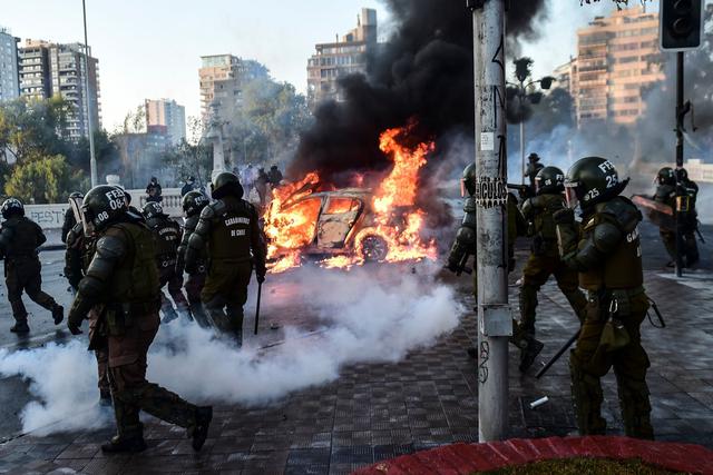 Decenas de encapuchados lanzaron piedras y rompieron los enormes ventanales del frontis del edificio, tiraron bombas molotov y gases lacrimógenos de la Policía al interior del vestíbulo. También quemaron al menos siete vehículos.