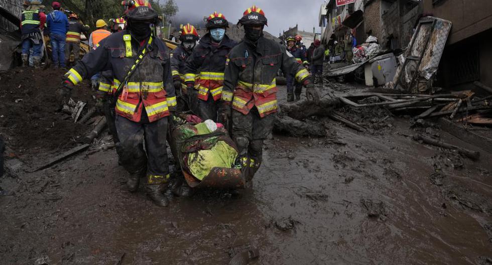 Los equipos de rescate se llevan el cuerpo de una víctima de una inundación repentina provocada por la lluvia que llenó los arroyos cercanos y reventó su mecanismo de contención en el área de La Gasca de Quito, Ecuador, el martes 1 de febrero de 2022. ( AP Foto/Dolores Ochoa).