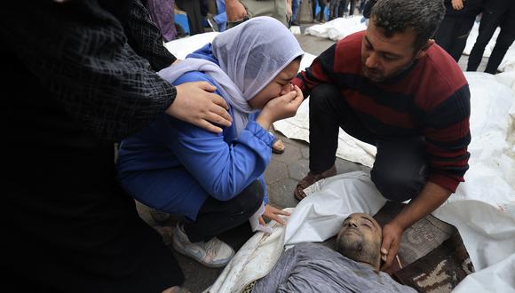 Palestinos lloran a sus familiares, muertos en un ataque israelí nocturno contra el campo de refugiados de Al-Maghazi, en el hospital Al-Aqsa en Deir Al-Balah, en el centro de la Franja de Gaza, el 25 de diciembre de 2023. (Foto de Mahmud HAMS / AFP)